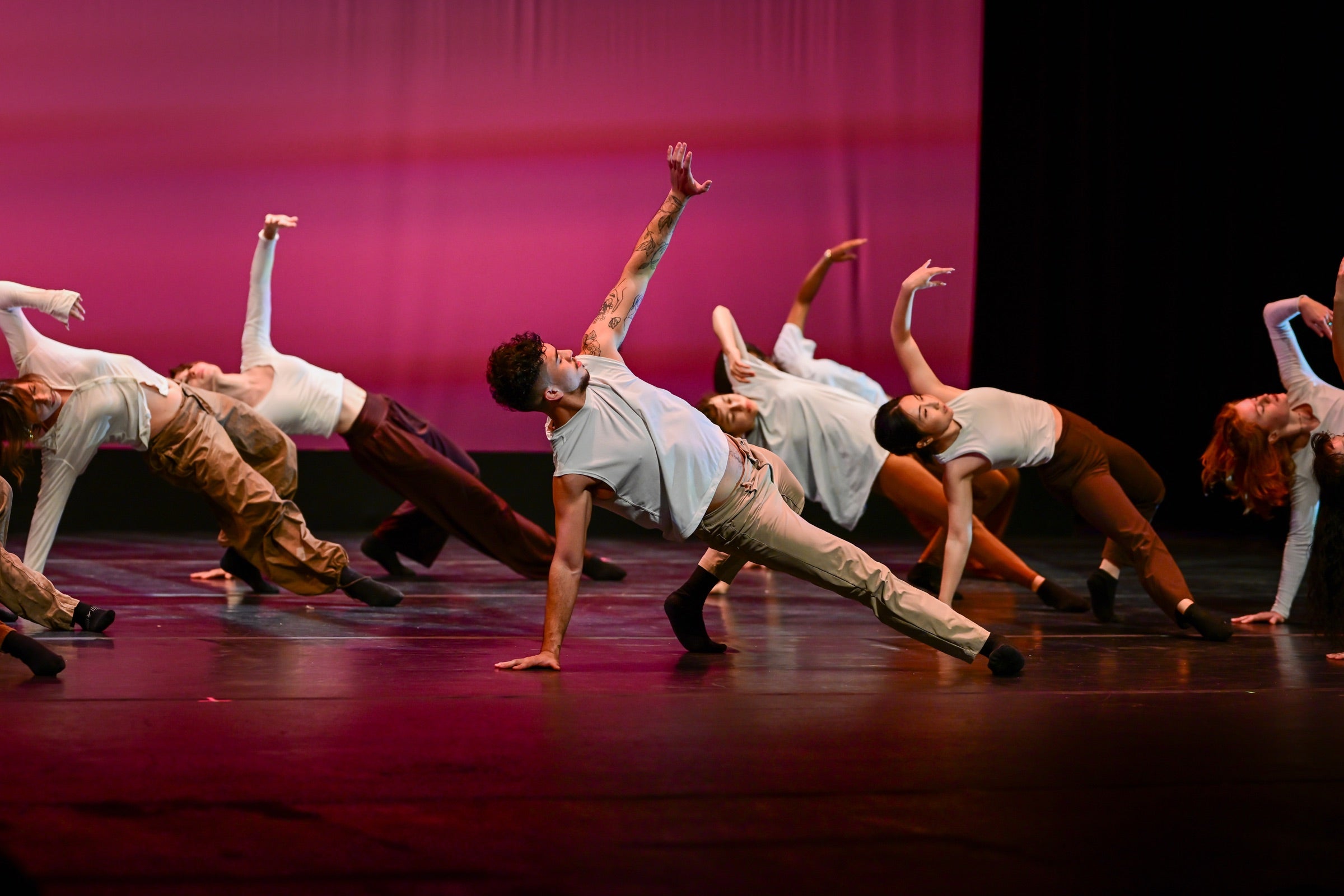 Adult dancers in contemporary class, movement in low light