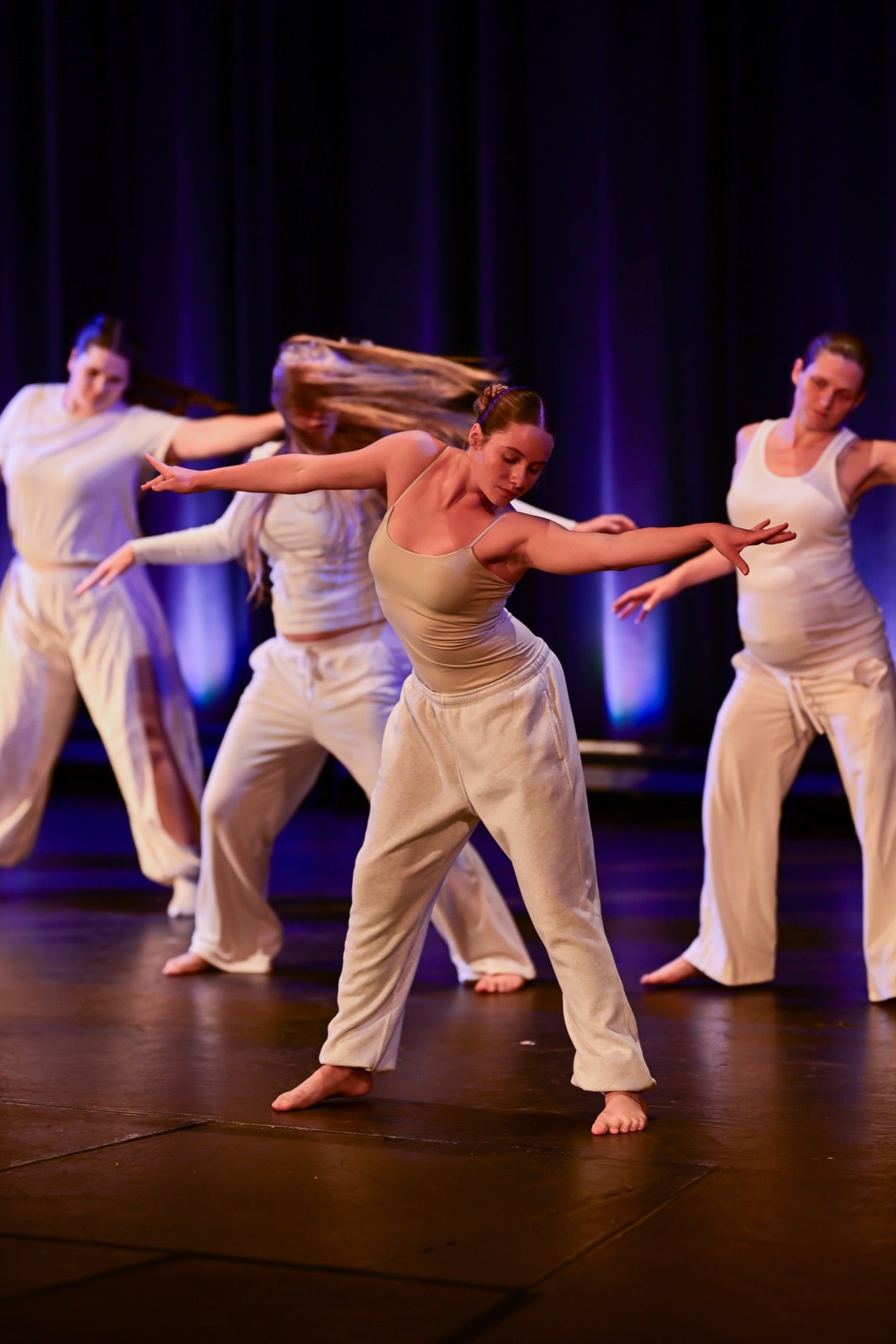 Contemporary dancer mid-movement with blue stage lighting